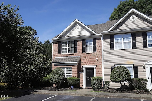 view of front of home with brick siding and uncovered parking