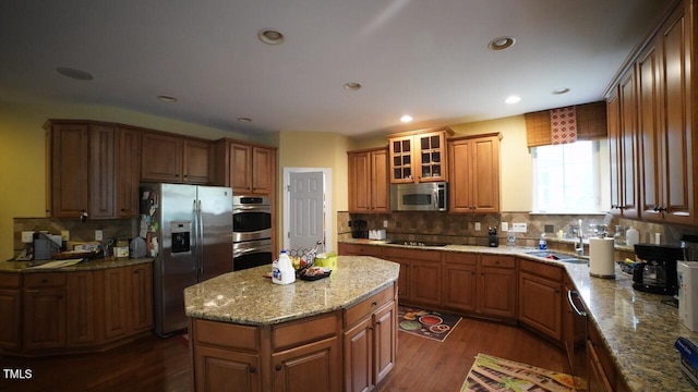 17832 Durrango Ct, Charlotte, NC 28278 - kitchen with appliances with stainless steel finishes, decorative backsplash, dark wood-type flooring, a sink, and a kitchen island