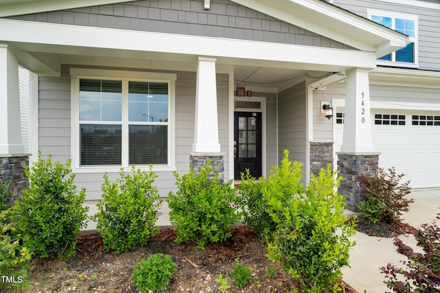 5420 Mill Dam Rd, Wake Forest, NC 27587 - doorway to property with a garage, stone siding, and covered porch