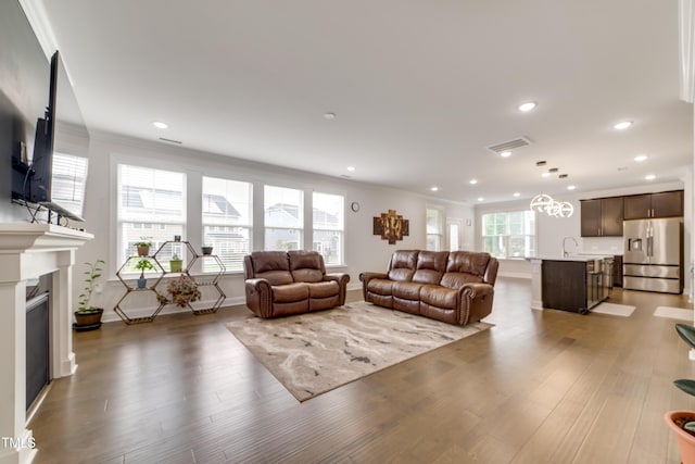 5420 Mill Dam Rd, Wake Forest, NC 27587 - living area with a glass covered fireplace, healthy amount of natural light, wood finished floors, recessed lighting, and crown molding
