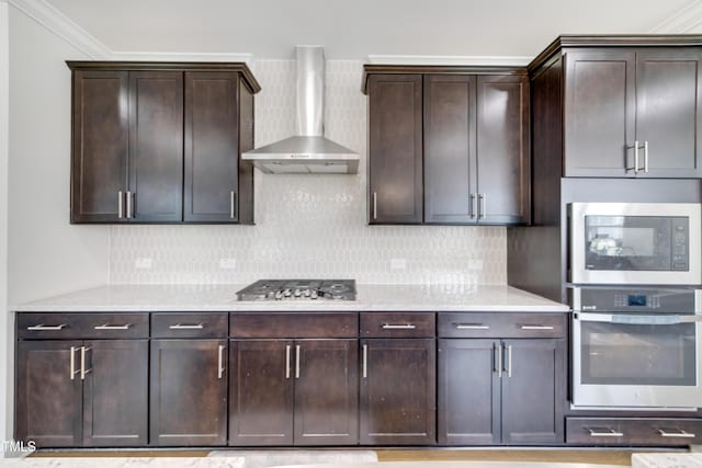 5420 Mill Dam Rd, Wake Forest, NC 27587 - kitchen featuring appliances with stainless steel finishes, wall chimney exhaust hood, tasteful backsplash, dark brown cabinetry, and crown molding