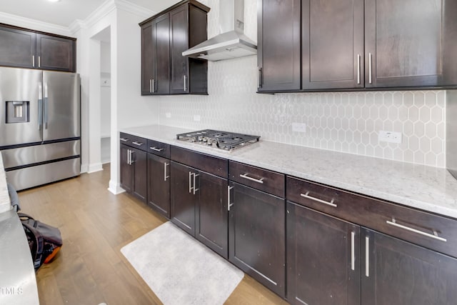 5420 Mill Dam Rd, Wake Forest, NC 27587 - kitchen featuring stainless steel appliances, wall chimney exhaust hood, ornamental molding, light wood-style floors, and dark brown cabinets