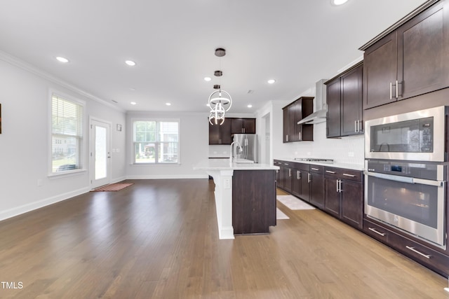5420 Mill Dam Rd, Wake Forest, NC 27587 - kitchen featuring appliances with stainless steel finishes, ornamental molding, light wood-style floors, light countertops, and dark brown cabinets