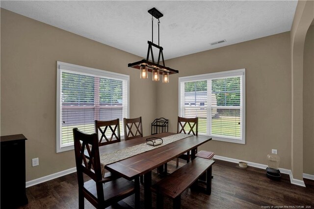 213 Windwood Dr, Stedman, NC 28391 - dining space with dark wood-style flooring, baseboards, arched walkways, a chandelier, and a textured ceiling