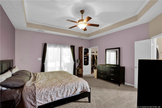 213 Windwood Dr, Stedman, NC 28391 - bedroom with a tray ceiling, light colored carpet, a walk in closet, ornamental molding, and a ceiling fan
