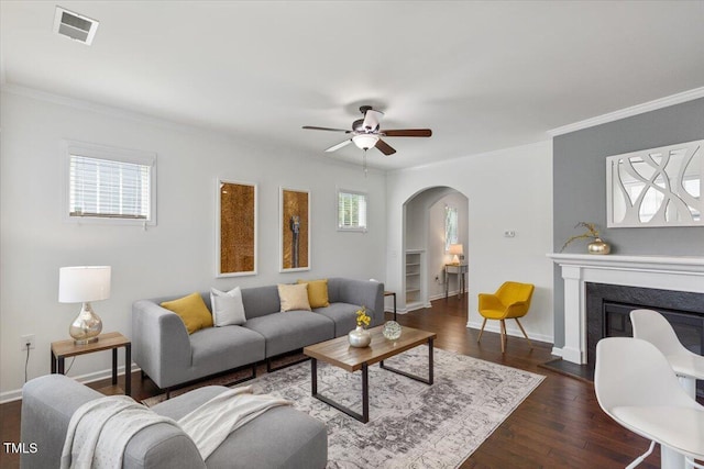 2837 Milano Ave, Apex, NC 27502 - living room with arched walkways, crown molding, a ceiling fan, baseboards, and dark wood-style flooring