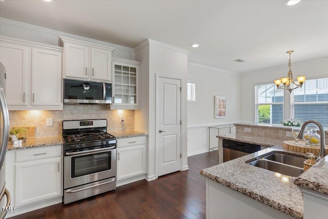 2837 Milano Ave, Apex, NC 27502 - kitchen with stainless steel appliances, a sink, dark wood-style flooring, a chandelier, and white cabinets