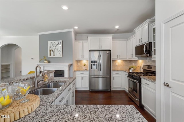 2837 Milano Ave, Apex, NC 27502 - kitchen featuring stainless steel appliances, a sink, arched walkways, ornamental molding, and white cabinetry