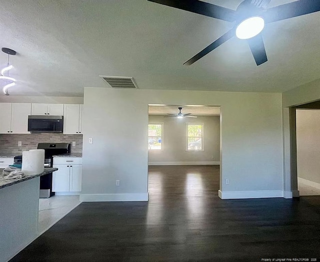 7690 Beverly Dr, Fayetteville, NC 28314 - kitchen featuring a ceiling fan, stainless steel range oven, open floor plan, white cabinets, and tasteful backsplash