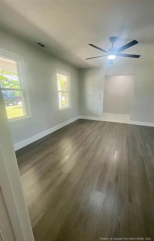 7690 Beverly Dr, Fayetteville, NC 28314 - empty room with dark wood-style flooring, baseboards, and a ceiling fan