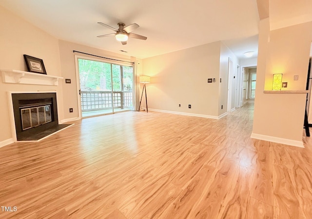 4120 Sedgewood Dr Unit 106, Raleigh, NC 27612 - unfurnished living room featuring ceiling fan, a glass covered fireplace, light wood-style flooring, and baseboards