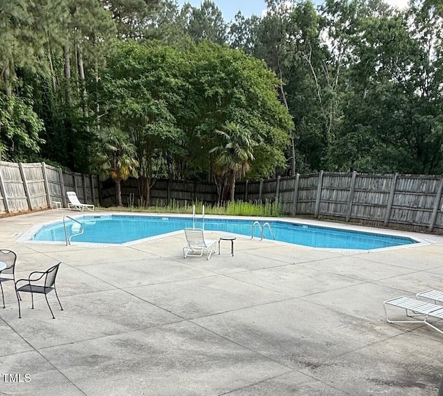 4120 Sedgewood Dr Unit 106, Raleigh, NC 27612 - view of pool with a fenced backyard, a patio area, and view of wooded area