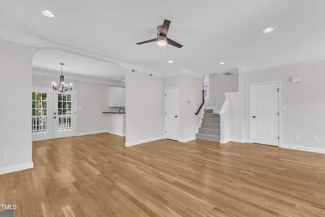 2204 Bellaire Ave, Raleigh, NC 27608 - unfurnished living room featuring ceiling fan, a chandelier, crown molding, stairs, and light wood-style flooring