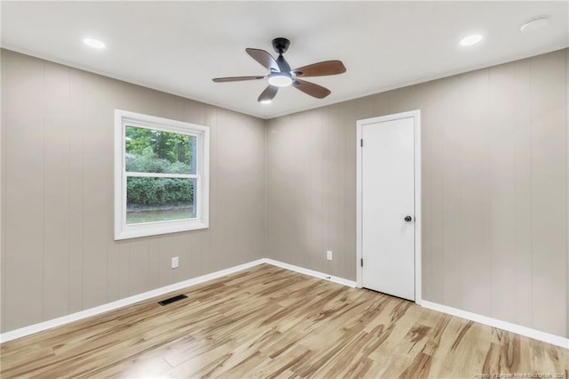 empty room with wood finished floors, ceiling fan, and baseboards