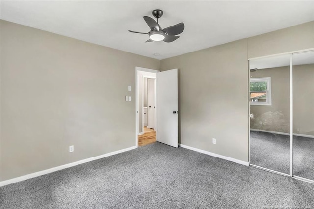 unfurnished bedroom with carpet floors, baseboards, a closet, and a ceiling fan
