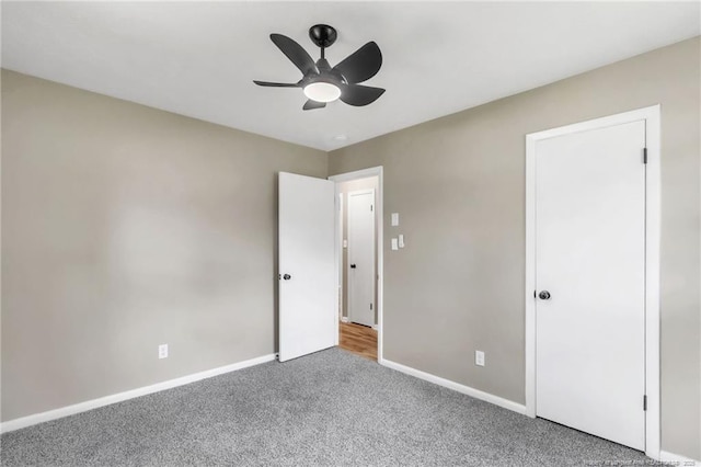 unfurnished bedroom featuring carpet floors, baseboards, and ceiling fan