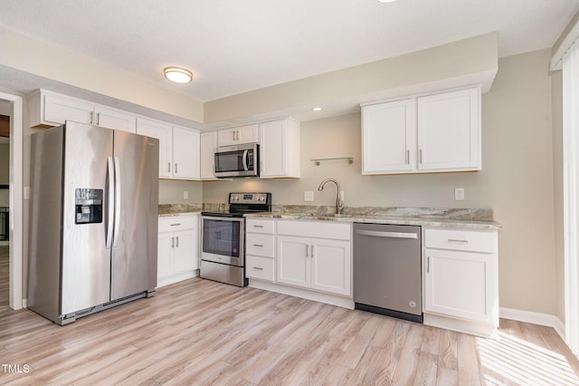 1304 Seaton Rd Unit 1, Durham, NC 27713 - kitchen with appliances with stainless steel finishes, a sink, light wood-type flooring, white cabinetry, and recessed lighting