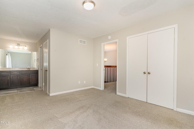 1304 Seaton Rd Unit 1, Durham, NC 27713 - unfurnished bedroom featuring light carpet, ensuite bathroom, baseboards, and a closet