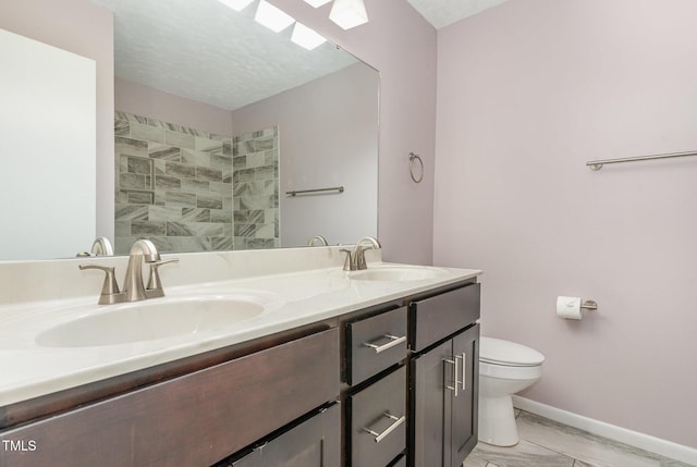 1304 Seaton Rd Unit 1, Durham, NC 27713 - bathroom featuring toilet, double vanity, baseboards, a tile shower, and marble look tile flooring
