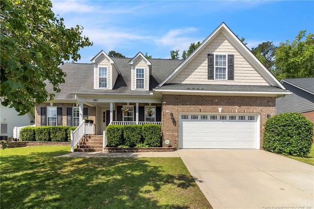 view of front of house with brick siding, driveway, covered porch, a front yard, and roof with shingles