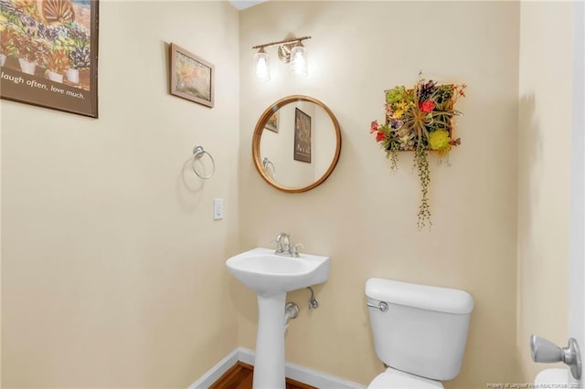 bathroom with toilet and baseboards