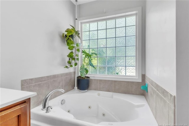 full bathroom with healthy amount of natural light, a whirlpool tub, and vanity