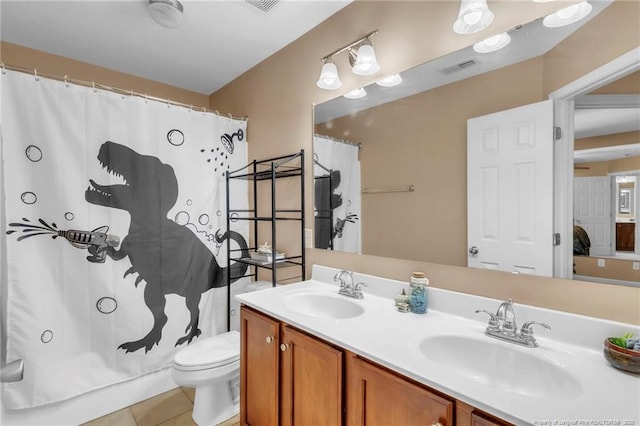 bathroom with tile patterned flooring, toilet, and double vanity