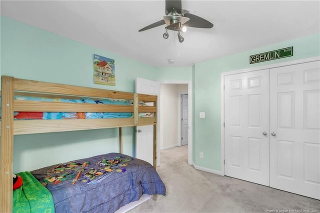 carpeted bedroom with baseboards, a closet, and ceiling fan