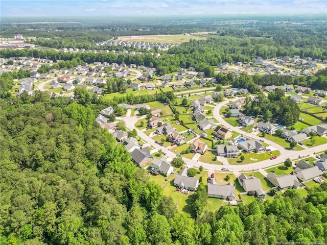aerial overview of property's location with nearby suburban area and a forest