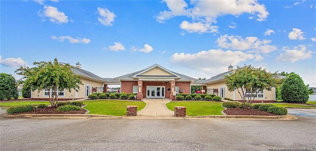 view of front of house with french doors, a front lawn, and brick siding