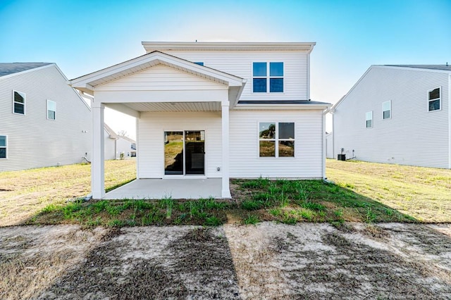 back of house with a patio and a lawn