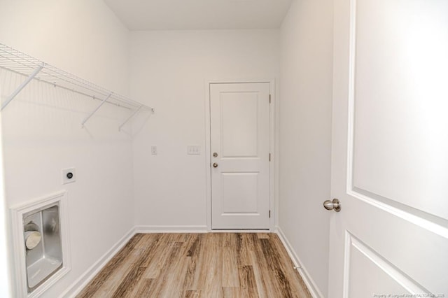 laundry area with hookup for an electric dryer, light wood finished floors, and baseboards