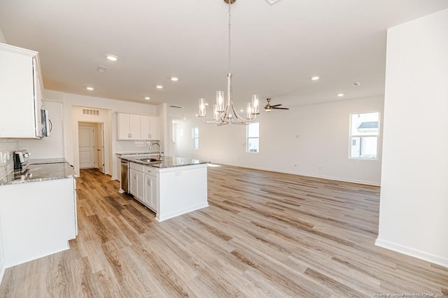 kitchen featuring appliances with stainless steel finishes, a sink, a chandelier, light wood-style flooring, and white cabinets