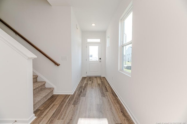 doorway featuring wood finished floors, stairway, and baseboards
