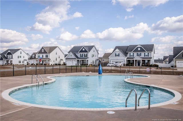 community pool featuring a residential view and a patio