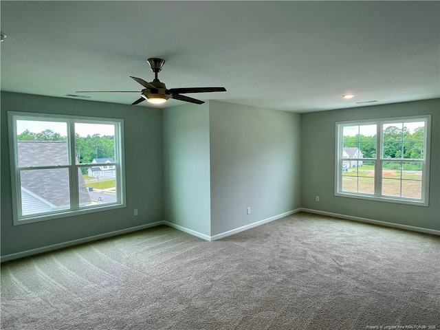 spare room with carpet, baseboards, and a ceiling fan