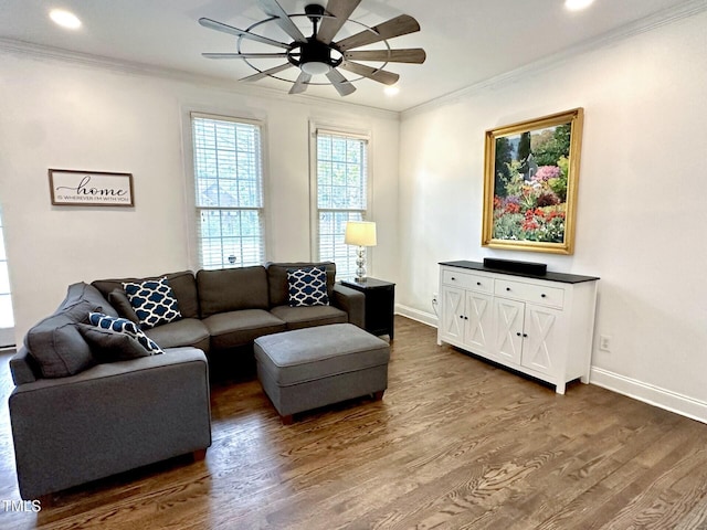 living area featuring crown molding, a ceiling fan, dark wood-type flooring, baseboards, and recessed lighting