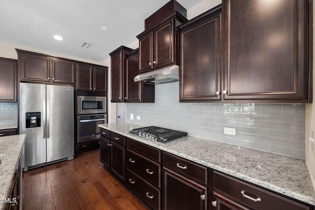 1103 Laurel Twist Rd, Cary, NC 27513 - kitchen with appliances with stainless steel finishes, under cabinet range hood, dark wood finished floors, tasteful backsplash, and light stone countertops