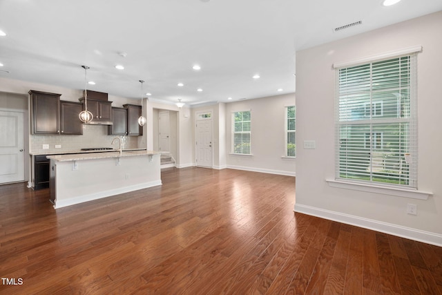 1103 Laurel Twist Rd, Cary, NC 27513 - kitchen featuring an island with sink, recessed lighting, a breakfast bar area, tasteful backsplash, and dark brown cabinetry