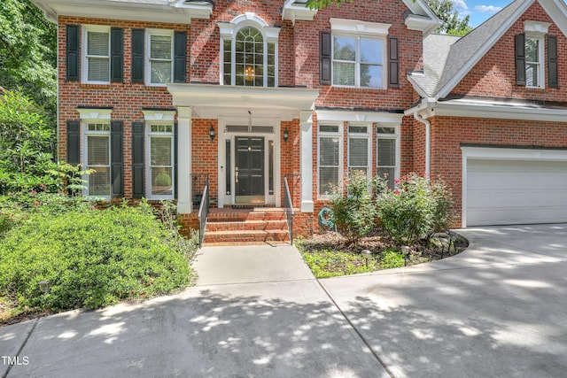 123 W Camden Forest Dr, Cary, NC 27518 - view of front of house with brick siding, a garage, and driveway