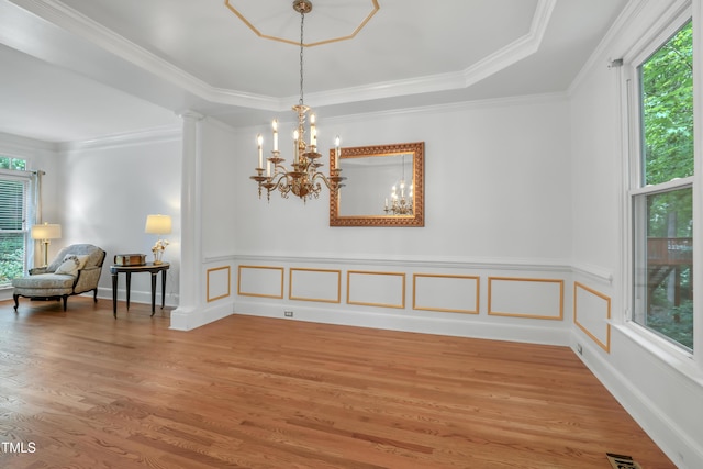 123 W Camden Forest Dr, Cary, NC 27518 - empty room featuring healthy amount of natural light, light wood finished floors, a chandelier, crown molding, and a wainscoted wall