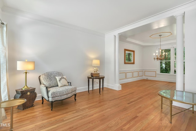 123 W Camden Forest Dr, Cary, NC 27518 - sitting room featuring decorative columns, wood finished floors, a tray ceiling, a chandelier, and ornamental molding