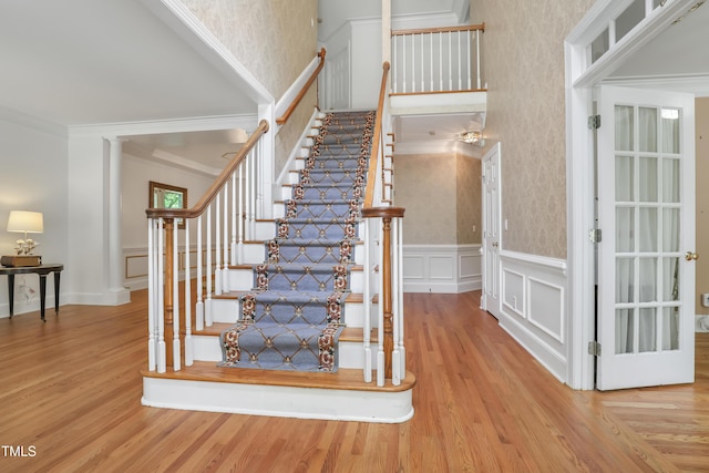 123 W Camden Forest Dr, Cary, NC 27518 - stairs with crown molding, wood finished floors, a decorative wall, wallpapered walls, and wainscoting