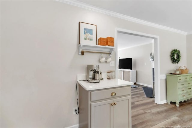 hallway featuring crown molding, light wood-style flooring, and baseboards
