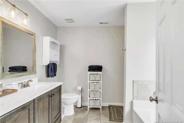 full bath featuring toilet, a bath, vanity, baseboards, and tile patterned flooring