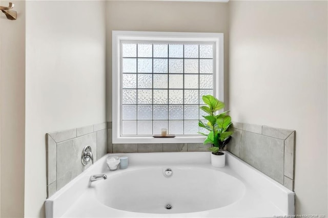 bathroom featuring healthy amount of natural light and a bath