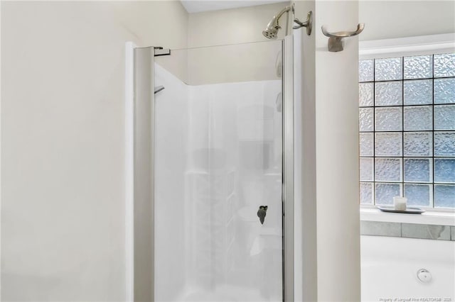 bathroom with a stall shower, plenty of natural light, and a bath