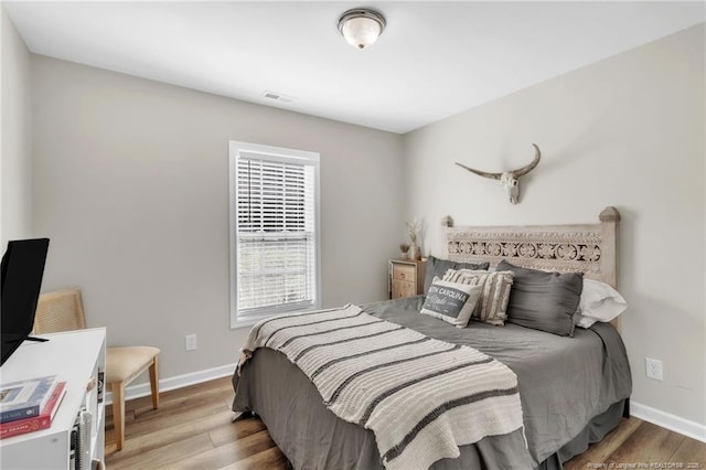 bedroom featuring wood finished floors and baseboards