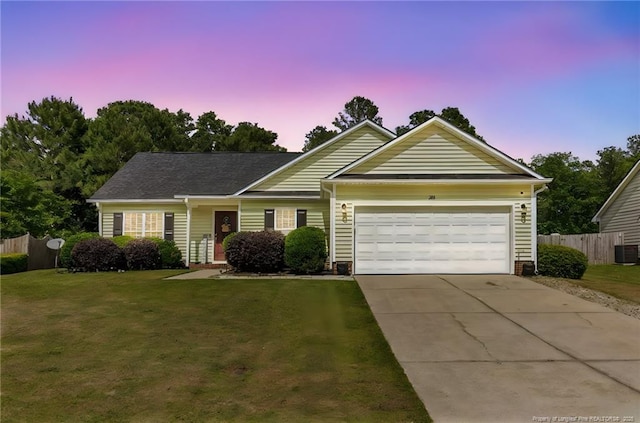 ranch-style home featuring an attached garage, concrete driveway, and central air condition unit