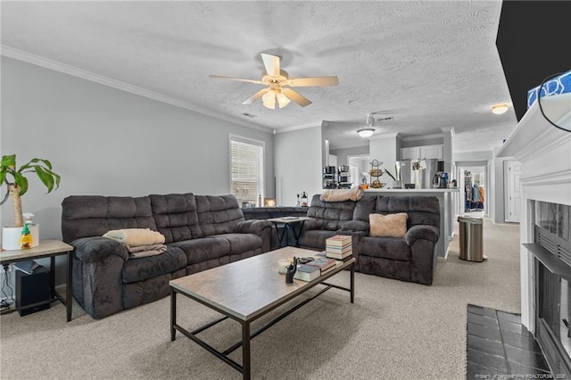 living area with light carpet, ceiling fan, ornamental molding, and a textured ceiling